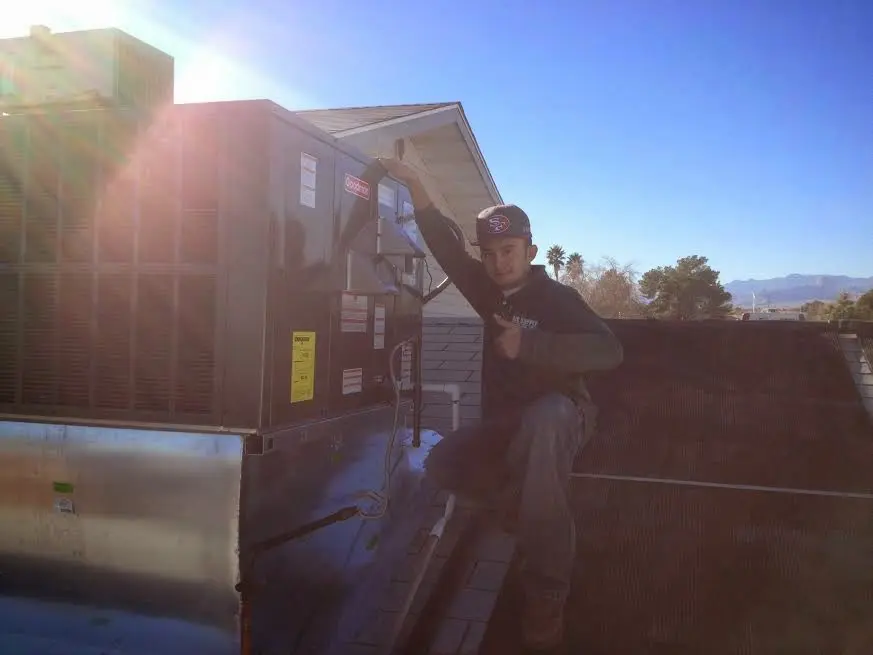 HVAC technician performing Heat Pump Repair on a rooftop unit in Four Square Mile